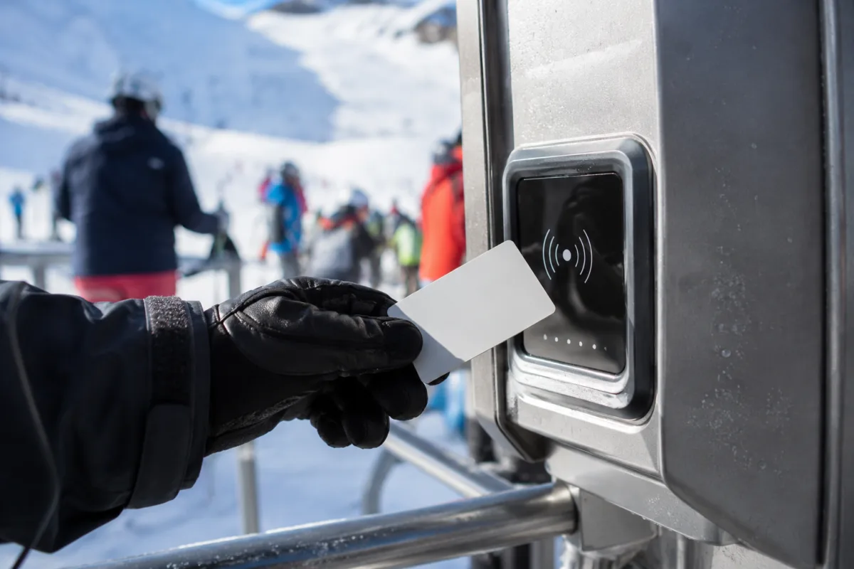 Gros plan sur un skipass journée posé sur un gant de ski près des caisses d'une station