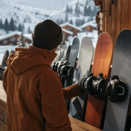 Rayonnage de snowboards et boots alignés dans un magasin de location en station de montagne